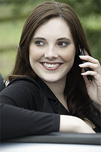Corporate head shot of a female model with a telephone in a car